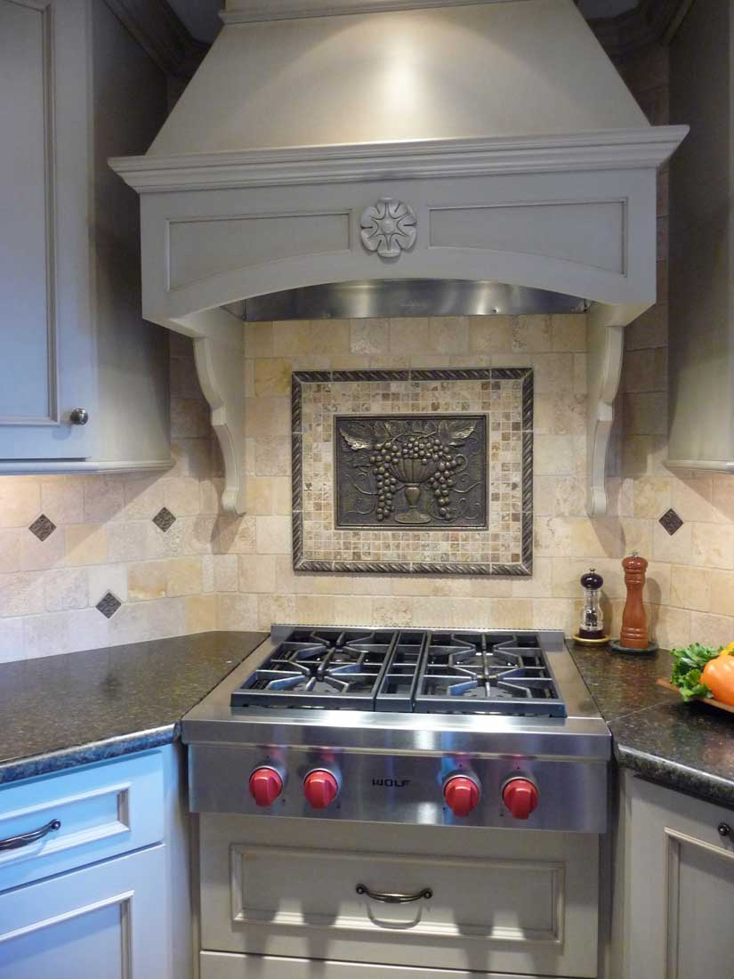 Stainless steel subzero and wolf 4 burner cooktop range with red knobs and custom range hood