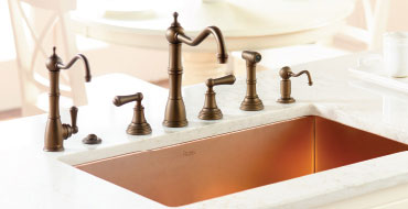 rohl faucet set in dark bronze with a soap dispenser, a removable spray and drinking faucet