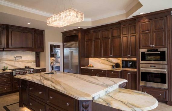 White brown kitchen with dark wood cabinetry and white countertops and island for a traditional kitchen