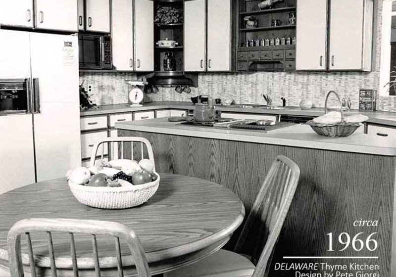 Open shelving and spice storage throughout a vintage kitchen and dining area with a round table
